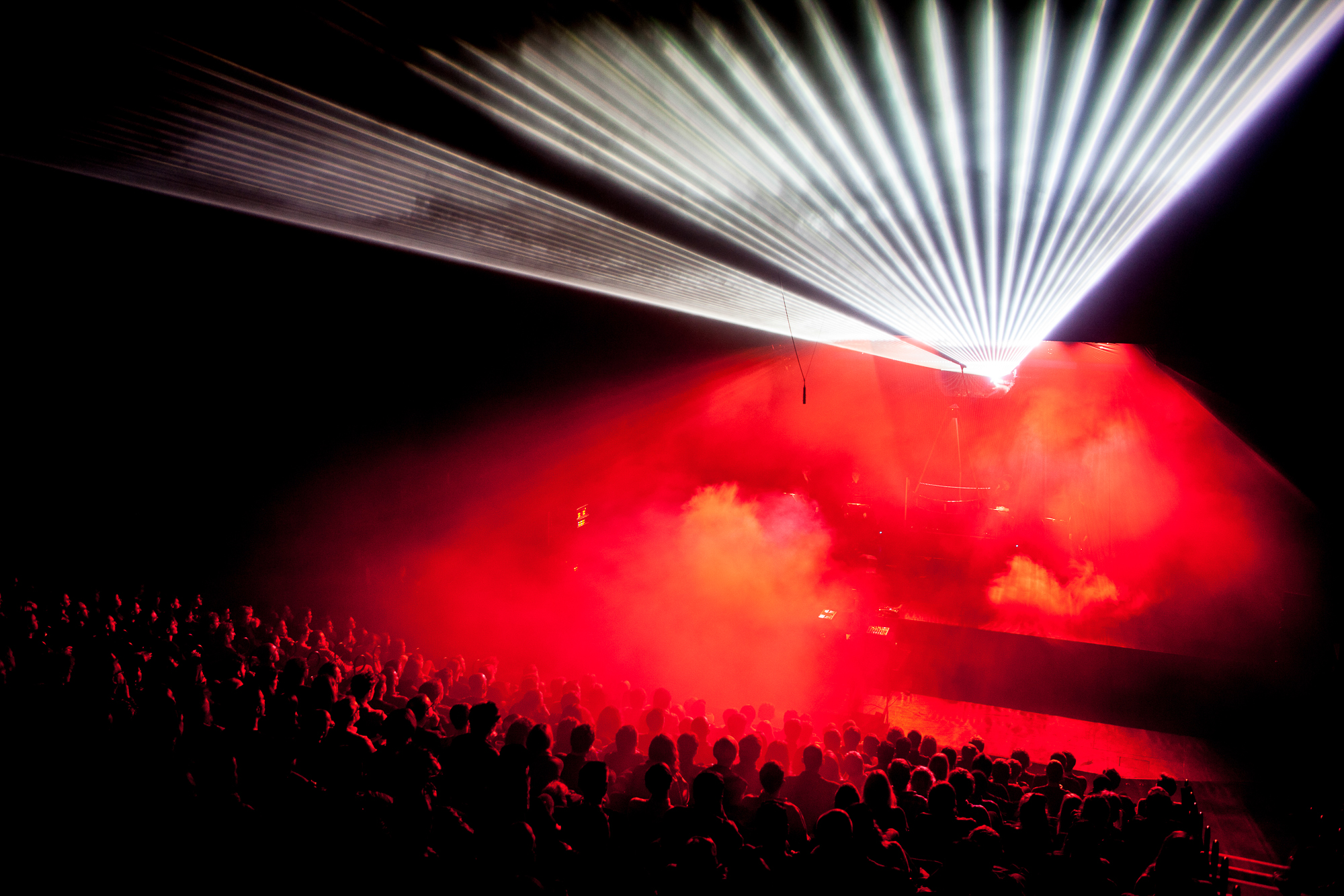 Audience looking at stage with red lights