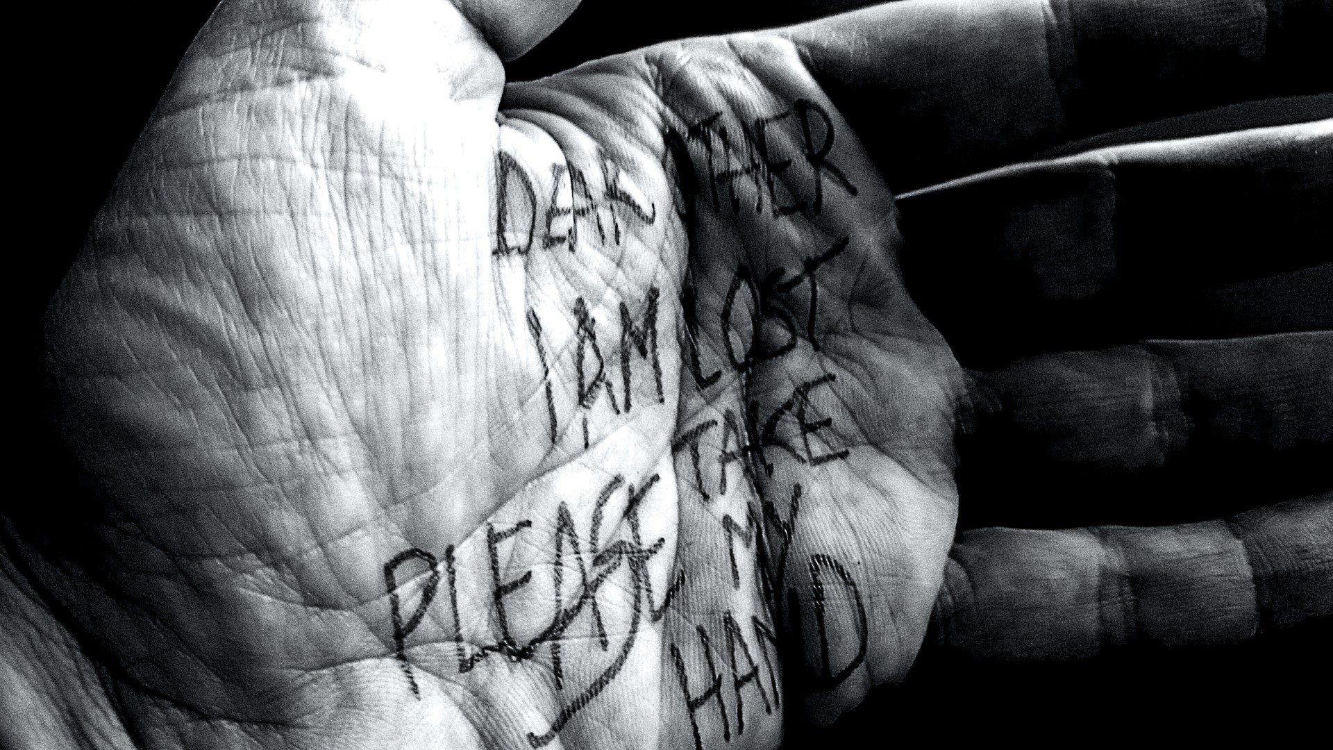 Black and white photo of a hand with writing on the palm