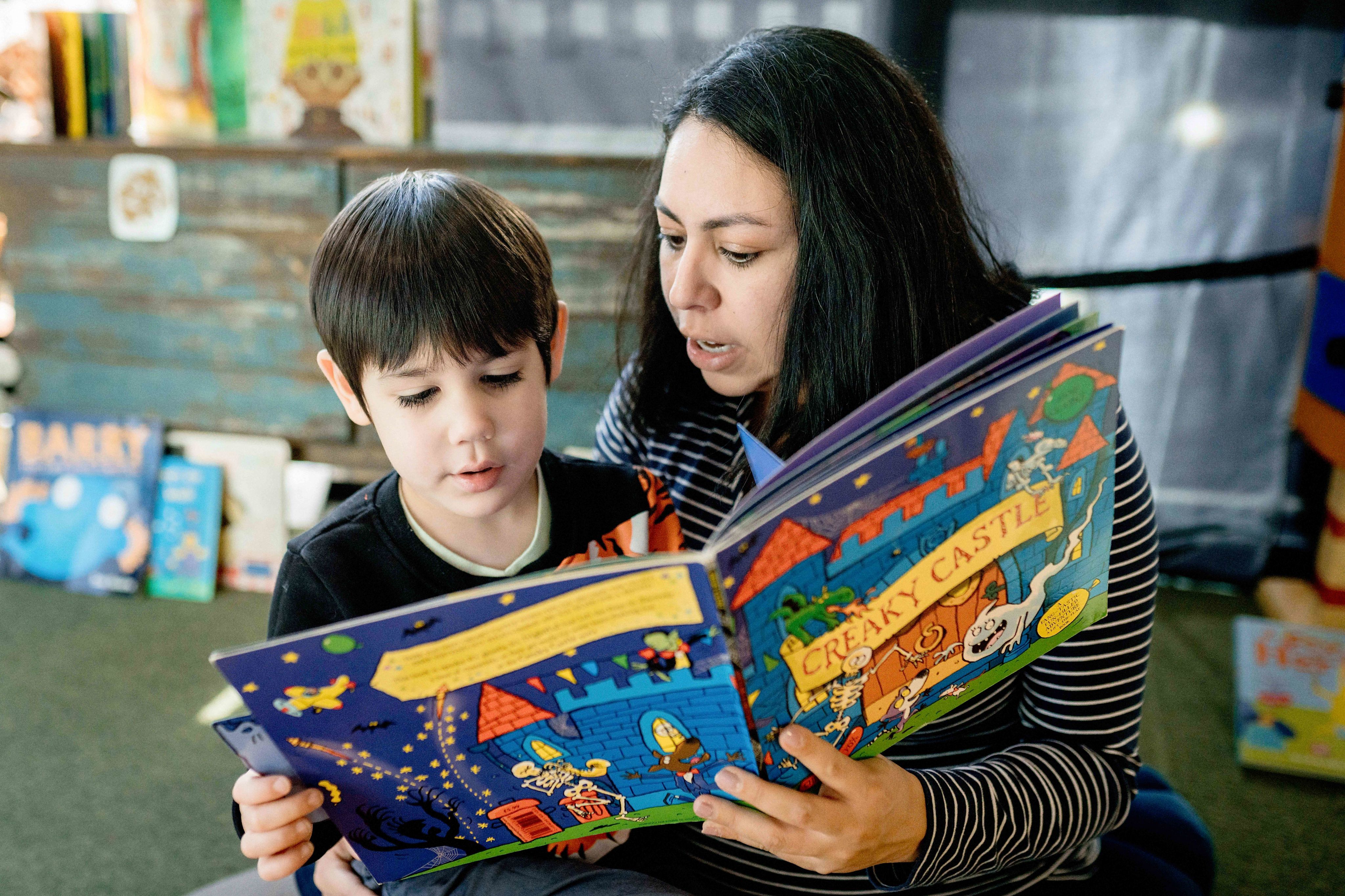 A child and adult reading together