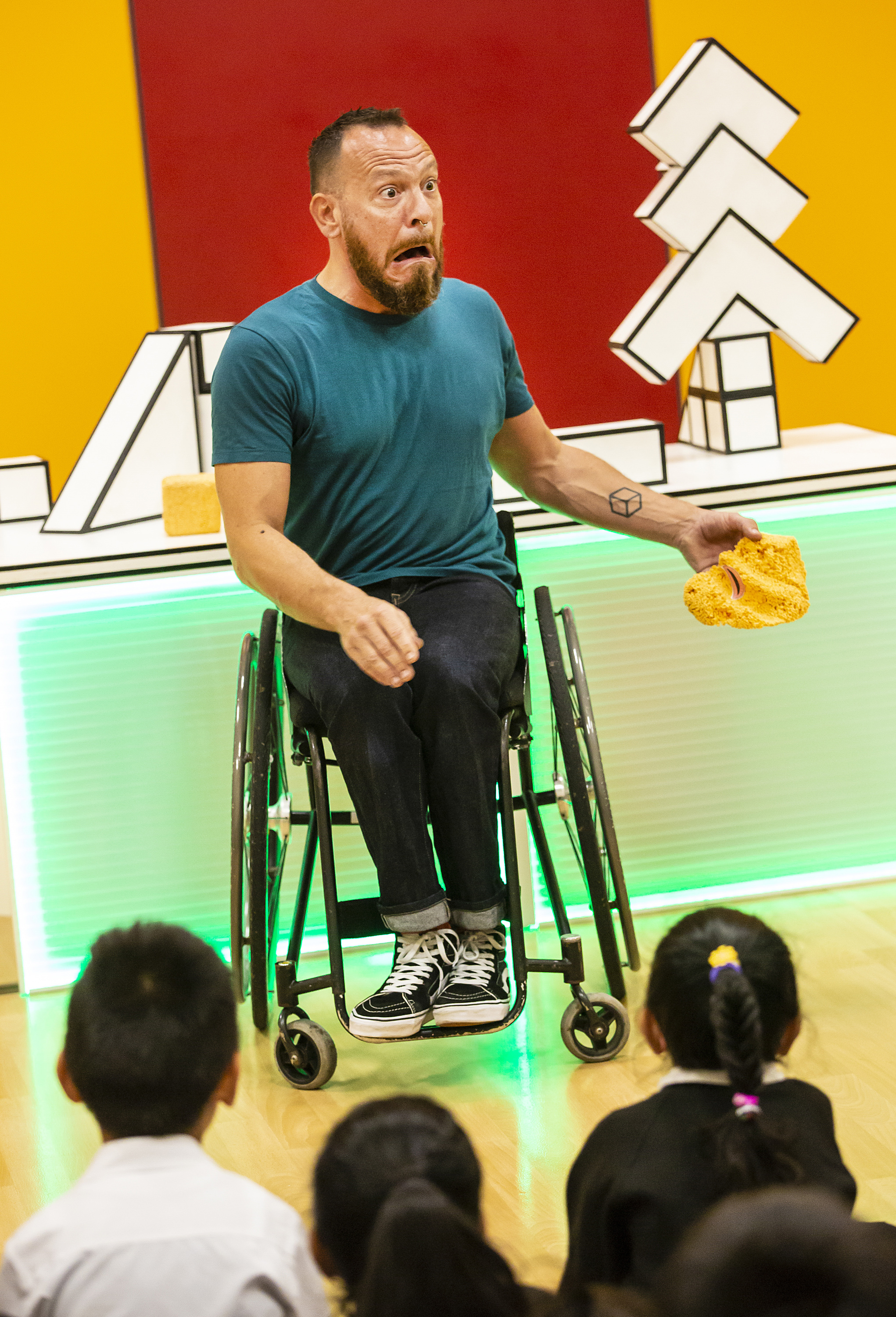 Man in wheelchair with audience of children