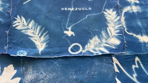 Cyanotype with place names and feathers as a pattern on the fabric. 