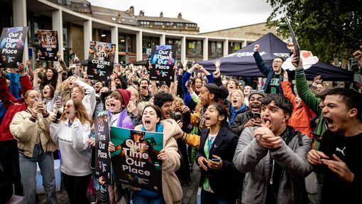 A crowd of people celebrating the announcement of Bradford as UK City of Culture for 2025. People can be seen jumping around and shouting in surprise and excitement. 